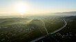 Aerial view of Gandia city and highway during sunrise, with fog covering the landscape in valencia, Spain