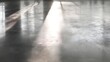 © Jojo* - Reflective concrete floor with sunlit streaks displays a muted gray tone and subtle texture.