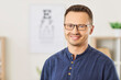 © Studio Romantic - Portrait of a happy man wearing glasses standing in an optical clinic. Eyewear or optic wear for people and business services, capturing the moment in a professional healthcare or optician setting.