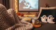 © Tiana_Geo - woman on sofa, wrapped in cozy knit blanket, enjoying spooky movie night at home for content about Halloween traditions, home entertainment, holiday celebrations. cozy night in during autumn season