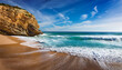 © Orion - serene beach with waves and rocky cliff under a blue sky