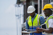 © ultramansk - Black professionals collaborating on a renewable energy project. A senior engineer and his partner from a Black owned business discuss a solar installation, representing diversity in tech.