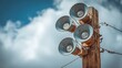 © JovialFox - Close up photograph of several multi directional round amplified emergency siren  or noon time horns on top of a wooden pole in a small town in Wisconsin.