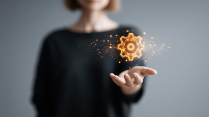 Wall Mural - person holds glowing gear symbol above their open palm, representing technology and innovation. back