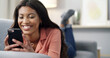 © Andrew G/peopleimages.com - Happy woman, relax or social media with phone on sofa for network service or app in home. Female person, user or lying with smile on mobile smartphone for internet, connection or online chat in house