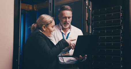 Laptop, talking and people with in server room for technical support, database or cybersecurity. Computer, teamwork and technicians with system upgrade in data center for network programming.