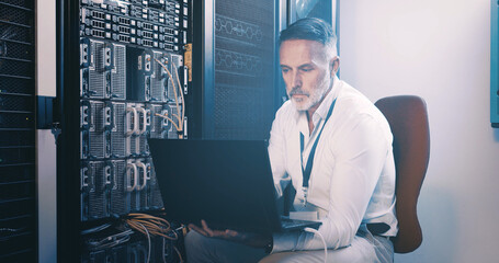 Server room, programmer and man with laptop, online reading and hardware problem solving. IT specialist, cyber security or mature person in workplace, pc and tech upgrade with inspection and coding