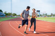 © Kawee - Diverse young man and woman running exercising together at stadium.