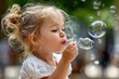 © YouraPechkin - Little Girl Blowing Bubbles in a Sunny Park, Childhood Fun and Joy