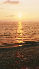 Wall Mural - Aerial view of the golden light on sea surface,Amazing waves ocean at sunset or sunrise sky background