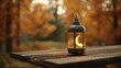 © Galih - Ornate lantern with crescent moon detail sits on weathered wood, autumn scene