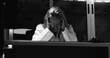 © Marco - Burned out female doctor in solitude, eyes closed and hands on neck, expressing mental fatigue and emotional collapse in grayscale workplace setting