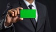 © My - Businessman displays a blank green card, showcasing presentation opportunity.