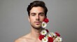 © Tetiana - Young caucasian male with floral adornment on shoulder against gray background