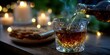 © Michael - Pouring a rich drink into a crystal glass beside a plate of cookies with soft candlelight and twinkling lights