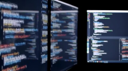 Displays show source code with colorful syntax highlighting.
