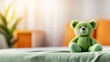 © tashechka - Soft green teddy bear sits on a bed in a cozy room with bright decor