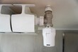 © nina blez - Close-Up of a White Thermostatic Radiator Valve with Temperature Control Dial Attached to Wall-Mounted Radiator for Central Heating System, Energy Efficiency, and Climate Regulation Concept