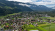 Aerial view of Haiming village in the inntal valley, Tyrol, Austria, showcasing houses, farms, green fields, and the majestic Austrian Alps