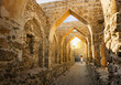 © Kirk Fisher - A tourist walks under ancient arches on a narrow path at Qal’at al-Bahrain Portuguese Fort, the ancient capital of Dilmun civilization, in Bahrain.