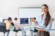 © Pixel-Shot - female teacher with notebook against students studying at school computer lab