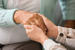 © Pixel-Shot - Senior woman with daughter holding hands at home, closeup