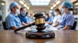 © Design Store - Gavel in the foreground with blurred medical professionals wearing masks and scrubs in the background symbolizing healthcare legal issues