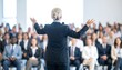 © beopaq - Businesswoman giving a presentation to a large audience
