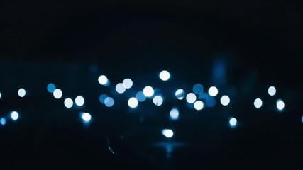 Soft glowing blue bokeh lights drifting gently in darkness creating a dreamy atmospheric scene with abstract depth and cinematic elegance in a seamless loop