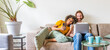© Davide Angelini - Multiracial young couple using computer laptop and smart mobile phone sitting on the sofa at home - Happy diverse husband and wife using pc online services - Technology life style concept