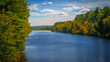 © Naya Na - Vibrant lakeshore autumn landscape over Massabesic Lake at NH Audubon Massabesic Center forest in Auburn, New Hampshire, with forest edges and open sky meet in a serene conservation setting.