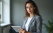 © wu - Portrait of a serious female trainer holding tablet and looking at the camera. High quality