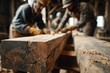 © Ілона Kozlovska - Rough wooden beam covered in sawdust with blurred workers performing woodworking in a rustic workshop