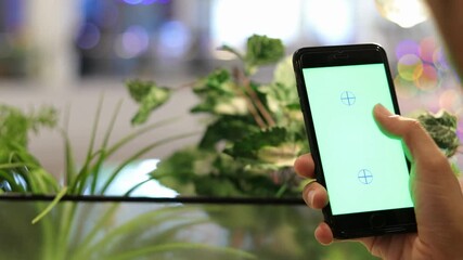 closeup person hand enjoys scrolling social network Internet on green screen. explores huge Internet space on smartphone green chroma keybackground