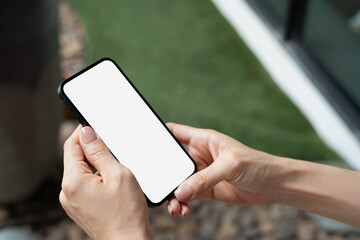Mockup blank screen cell phone, woman hands holding smartphone with empty screen for online marketing or mobile app design, close up