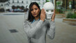 © Krakenimages.com - Woman holding mask on urban street while unveiling face outdoors in city setting, representing identity, mystery, and transformation.