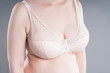 © staras - Large saggy breasts in a push-up bra, breastfeeding underwear, gray background
