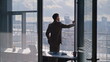 © stockbusters - Corporate leader watching skyline reflecting ambitions. Thoughtful sad worker