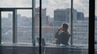 Rich person taking coffee break looking big office window. Man typing computer
