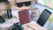 © Md. Tanjim Tanvir - Travel essentials flat lay with passport, map, camera, sunglasses, headphone, and phone for vacation, tourism, and adventure trip