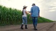© Victoriia - Farmers woman man teamwork in corn field. Agricultural industry. Farmers man woman with digital tablet inspecting crops in corn field. Digital technologies in agriculture. Business people growing corn