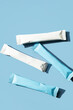 © zhennyzhenny - White and blue sachets of collagen supplement. Beauty and health product on blue background with copy space.