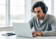 © Yhs City - Young man in headphones focused on his laptop
