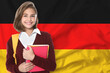 © New Africa - Student with backpack and notebooks against flag of Germany. Language school
