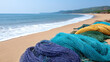 © venusvi - Colorful fishing nets lie on sandy beach, contrasting against serene waves and lush hills, capturing coastal tranquility and marine life.