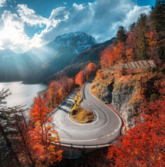 Wall Mural - aerial view of winding mountain road at sunset in autumn. alps, italy. curved alpine road, snowy roc