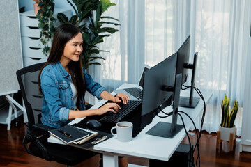 Young Asian in IT developer creating with typing online information on pc with coding program data of website application, wearing jeans shirt. surrounded by safety analysis two screens. Stratagem.