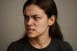 © Татьяна Евдокимова - Portrait of a suspicious young woman frowning and expressing distrust, looking sideways with an intense gaze
