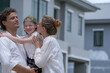 © ultramansk - A hopeful young family looks towards their future outside a new modern home. The father holds their daughter, who points excitedly, as the mother smiles, dreaming of their life together.