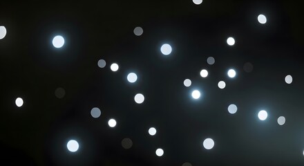 Abstract background of blurred glowing white bokeh lights against a dark night sky.